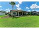 Well maintained backyard featuring lush green grass, mature landscaping, and a screened lanai at 7781 Grande Shores Dr, Sarasota, FL 34240