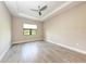 Bedroom with neutral walls, ceiling fan, and large window with outdoor view at 7781 Grande Shores Dr, Sarasota, FL 34240