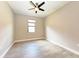 A well-lit bedroom featuring wood tile floors, a ceiling fan, and a window with blinds at 7781 Grande Shores Dr, Sarasota, FL 34240