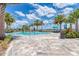 Beautiful community pool surrounded by lush landscaping, turquoise umbrellas and lounge chairs at 7781 Grande Shores Dr, Sarasota, FL 34240