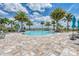 Resort-style community pool with spa, surrounded by palm trees and ample lounge seating at 7781 Grande Shores Dr, Sarasota, FL 34240