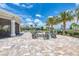 Inviting community fire pit and lounge area with beautiful pavers, lush landscaping and towering palm trees at 7781 Grande Shores Dr, Sarasota, FL 34240
