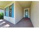 Inviting entryway with brick pavers, a textured wall, and a blue front door with glass inserts at 7781 Grande Shores Dr, Sarasota, FL 34240