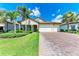 Beautiful single-Gathering home with a paved driveway, two-car garage, and well-maintained front yard at 7781 Grande Shores Dr, Sarasota, FL 34240
