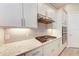 Close-up of kitchen featuring gas range, herringbone backsplash, and quartz countertops at 7781 Grande Shores Dr, Sarasota, FL 34240