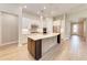 Bright, open kitchen with island, stainless steel appliances, white cabinets, and wooden floor at 7781 Grande Shores Dr, Sarasota, FL 34240