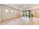 Spacious main bedroom featuring tile flooring, tray ceilings, recessed lighting, and sliding glass doors at 7781 Grande Shores Dr, Sarasota, FL 34240