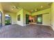 Covered brick patio featuring multiple ceiling fans, sliding doors, and views of a backyard at 7781 Grande Shores Dr, Sarasota, FL 34240