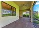 The covered brick patio features a ceiling fan and views of a landscaped backyard and pool at 7781 Grande Shores Dr, Sarasota, FL 34240