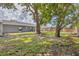 Mature trees provide shade in the backyard, complemented by a covered patio at 8258 San Jacinto Ave, North Port, FL 34287