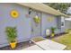 A charming front door with sunflower accents, potted plants, and a welcoming 'bee happy' sign for added curb appeal at 8258 San Jacinto Ave, North Port, FL 34287