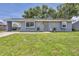Charming single-story home with gray siding, sunflowers, a well-manicured lawn and a convenient carport at 8258 San Jacinto Ave, North Port, FL 34287