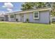 Quaint single-story home with a gray exterior, yellow sunflowers, and a lovely lawn, perfect for curb appeal at 8258 San Jacinto Ave, North Port, FL 34287