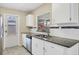 Bright kitchen features white cabinets, stainless steel appliances, granite countertops, and tiled backsplash at 8258 San Jacinto Ave, North Port, FL 34287