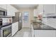 Bright kitchen features white cabinets, stainless steel appliances, granite countertops, and tiled backsplash at 8258 San Jacinto Ave, North Port, FL 34287