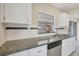 Bright kitchen features white cabinets, stainless steel appliances, granite countertops, and tiled backsplash at 8258 San Jacinto Ave, North Port, FL 34287