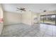 Open-concept living room with tile flooring, ceiling fans, and sliding glass doors leading to outdoor space at 8258 San Jacinto Ave, North Port, FL 34287
