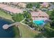 Aerial view of the community pool, clubhouse, bridge, and nearby pond at 8261 Miramar Way # 8261, Lakewood Ranch, FL 34202