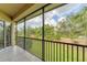 Screened in balcony with black railing and views of the beautiful green landscaping at 8261 Miramar Way # 8261, Lakewood Ranch, FL 34202