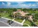 Aerial view of the community clubhouse surrounded by palm trees, manicured landscaping and parking at 8261 Miramar Way # 8261, Lakewood Ranch, FL 34202