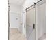 Hallway view showcasing a sliding barn door with wood floors and white trim at 8261 Miramar Way # 8261, Lakewood Ranch, FL 34202
