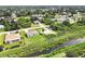 An aerial view of homes near a tranquil canal, set amidst lush greenery and a serene neighborhood at 8429 Malcolm Ave, North Port, FL 34287