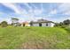 Green backyard with houses in the distance showcasing the property's peaceful setting at 8429 Malcolm Ave, North Port, FL 34287