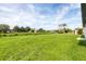 Large grassy backyard with green grass and distant neighborhood houses at 8429 Malcolm Ave, North Port, FL 34287