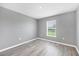 Bedroom featuring gray walls, vinyl floors, a window with a view, and modern trim at 8429 Malcolm Ave, North Port, FL 34287