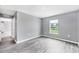 Bedroom with neutral walls, wood-look flooring, and natural light from the window at 8429 Malcolm Ave, North Port, FL 34287