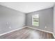 Bedroom featuring gray walls, vinyl floors, a window with a view, and modern trim at 8429 Malcolm Ave, North Port, FL 34287