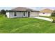Single-story home boasts a well-kept lawn and a concrete driveway leading to an attached garage at 8429 Malcolm Ave, North Port, FL 34287