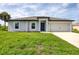 Charming single-story home with a well-manicured lawn and a welcoming blue front door at 8429 Malcolm Ave, North Port, FL 34287