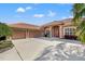 Beautiful home featuring a tile roof, three-car garage and a well-manicured front yard at 8445 Lone Eagle Way, Sarasota, FL 34241