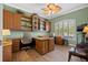 Well-lit home office with custom built-ins, ample storage, and wood flooring at 8445 Lone Eagle Way, Sarasota, FL 34241