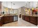 Spacious kitchen with granite countertops, custom dark wood cabinets, stainless steel appliances, and decorative pendant lights at 8445 Lone Eagle Way, Sarasota, FL 34241