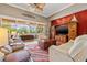 Spacious living room with large windows to outdoor lanai, leather furniture, television and wooden entertainment center at 8445 Lone Eagle Way, Sarasota, FL 34241