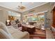 Bright living room features high ceilings, neutral walls, leather furniture, and sliding glass doors to the outdoor lanai at 8445 Lone Eagle Way, Sarasota, FL 34241