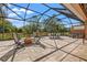 Large screened-in patio with a firepit, jacuzzi, lounge chairs and dining table at 8445 Lone Eagle Way, Sarasota, FL 34241