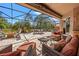 Expansive screened patio with a fire pit, seating areas, jacuzzi and lush greenery beyond at 8445 Lone Eagle Way, Sarasota, FL 34241