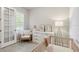 Cozy bedroom featuring neutral decor, a crib, and a comfy chair at 8641 Rain Song Rd, Sarasota, FL 34238