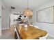 Dining room with modern light fixture and large table adjoining a white kitchen at 8641 Rain Song Rd, Sarasota, FL 34238