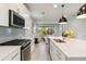 Open concept kitchen with stainless steel appliances and modern countertops; views to the living room at 8641 Rain Song Rd, Sarasota, FL 34238