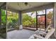 Enjoy outdoor living in this screened lanai, featuring comfortable seating and lush landscaping for privacy at 8641 Rain Song Rd, Sarasota, FL 34238