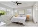 Serene main bedroom featuring large windows, neutral decor, and a ceiling fan at 8641 Rain Song Rd, Sarasota, FL 34238