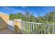Balcony view with white railing overlooking lush greenery and blue skies at 8907 White Sage Loop, Lakewood Ranch, FL 34202