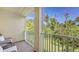 Balcony area with outdoor seating offering a relaxing view of mature trees at 8907 White Sage Loop, Lakewood Ranch, FL 34202