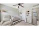 Cozy Bedroom featuring a classic white crib, comfortable chair, and warm, inviting decor for a peaceful atmosphere at 8907 White Sage Loop, Lakewood Ranch, FL 34202