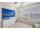 Airy Bedroom featuring a mounted television, comfortable chair, and a sunny window nook filled with books at 8907 White Sage Loop, Lakewood Ranch, FL 34202