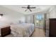 Primary bedroom with a ceiling fan, wood floors, dresser, and access to balcony at 8907 White Sage Loop, Lakewood Ranch, FL 34202